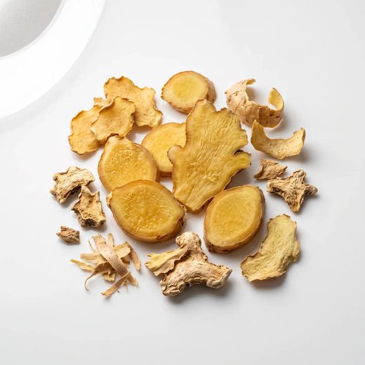 Fresh ginger root beside a dish of ginger powder